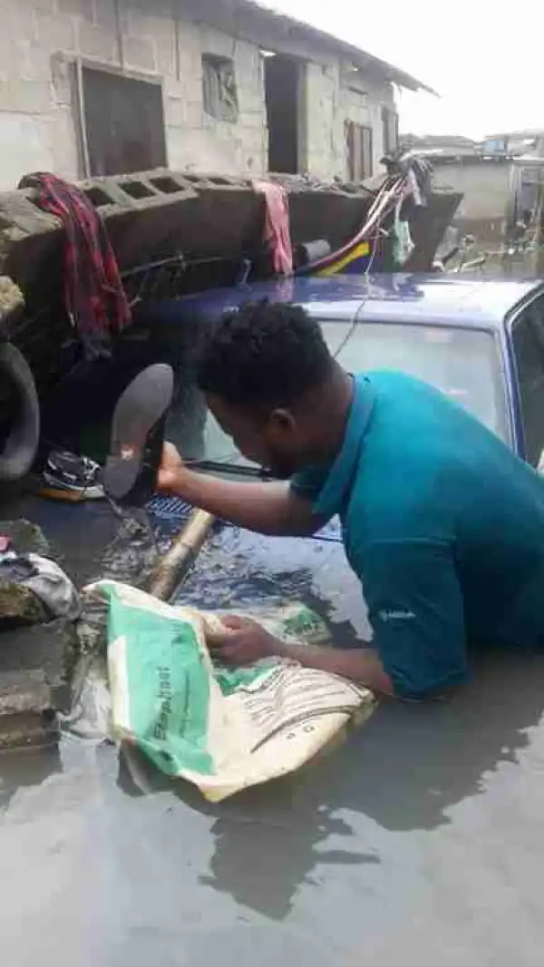 See This Funny Picture Of A Man Smiling Outside His Flooded Home In Lagos (Photos)